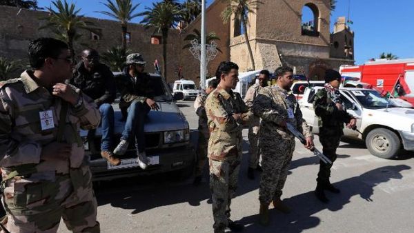 Members of the Libyan security forces and armed civilians monitor a check point at Martyrs square in Tripoli. (AFP PHOTO/MAHMUD TURKIA)