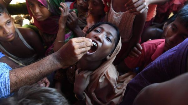 A Rohingya refugee receives an oral cholera vaccine from a Bangladeshi volunteer at the Thankhali refugee camp. (Indranil Mukherjee / AFP)