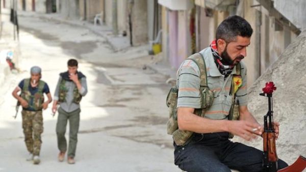A rebel fighter of the Syrian Kurdish Popular Protection Units (YPG) has a flower in his Russian made 'AK-47' kalashnikov gun as he holds a position in the Sheikh Maqsoud neighbourhood in the Syrian city of Aleppo. AFP Photo