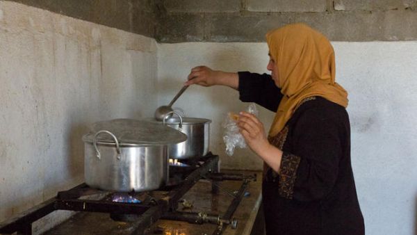 صورة "تعبيرية" لـ لاجئة سورية تطبخ في المطبخ العام في مخيم الزعتري