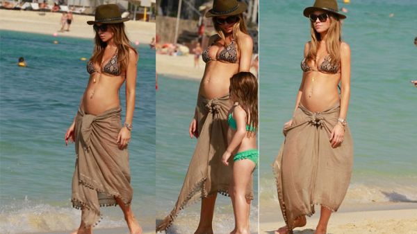 British model Abbey Clancy walks with her daughter down a beach in Dubai. (Image: Daily Mail)