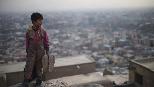 Afghan shoe-shine boy looks on from a hillside as he waits for customers in Kabul. (AFP)
