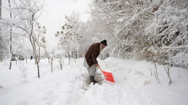An elderly Afghan man shovels snow in Kabul on February 5, 2017. (AFP/Shah Marai)