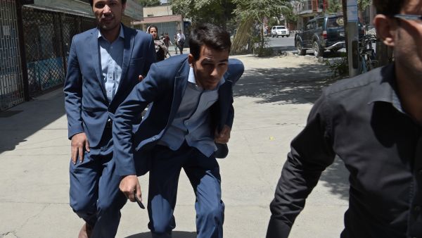 Afghan residents run at the site of a suicide blast near Iraq's embassy in Kabul. (AFP) 