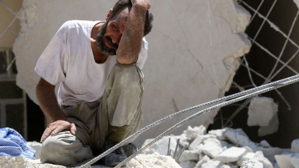 A man pictured in the rubble of a collapsed building following reported air strikes in Aleppo, northern Syria, on July 17, 2016 (AFP/Thaer Mohammed)