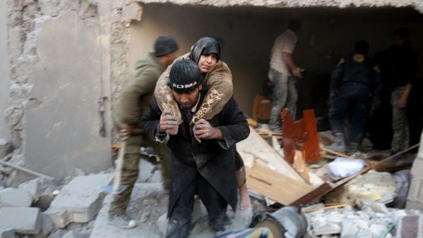 A man carries a woman from the rubble of a building following reported airstrikes on Aleppo's rebel-held district of al-Hamra on November 20, 2016. (AFP/Thaer Mohammed)
