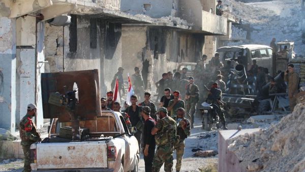 Syrian government forces gather amidst destruction in the largely deserted Palestinian refugee camp of Handarat, north of Aleppo. (AFP/File) 