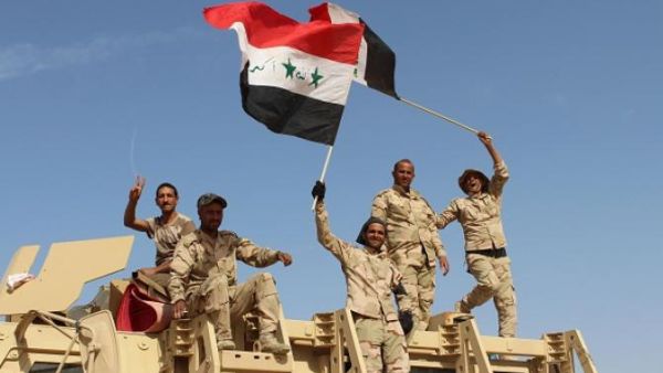 Iraqi government forces wave their national flags on March 10, 2016, after retaking the town of Zankura, northwest of Ramadi, from Daesh in Anbar province. (AFP/Moad Al-Dulaimi) 
