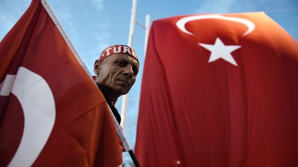 A Pro-Erdogan supporter holds a Turkish national flag during a rally at Taksim Square in Istanbul on July 18, 2016 (AFP/Aris Messinis)