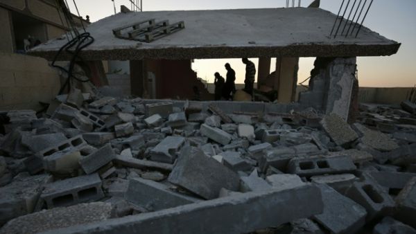 Palestinians stand near a house that was demolished by Israeli authorities in the Qalandia refugee camp, between Jerusalem and Ramallah. (AFP/Abbas Momani) 