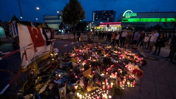 andles and flowers lie in front of the Olympia-Einkaufszentrum shopping centre on July 23, 2016 in Munich, southern Germany, one day after a teenage German-Iranian gunman killed nine people and wounded 16. (AFP/Sven Hoppe)