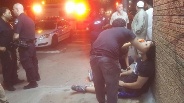 Passers-by attend to Muslim teen violently beaten outside mosque. (Twitter) 