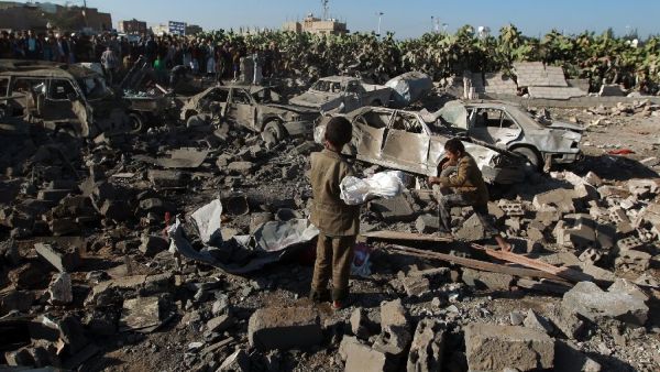Yemenis stand at the site of a Saudi air strike against Huthi rebels near Sanaa Airport on March 26, 2015 (AFP/Mohammed Huwais)
