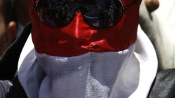 متظاهر يمني وقد لف وجهه بالعلم الوطني. متظاهر يمني وقد لف وجهه بالعلم الوطني.