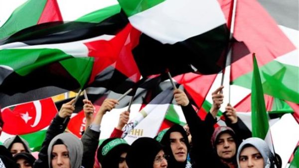 نساء تركيات يرفعن أعلاما فلسطينية.