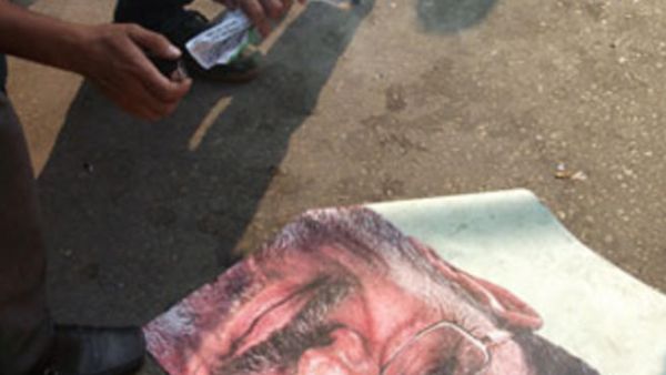 متظاهر يحاول حرق صورة الرئيس مرسي