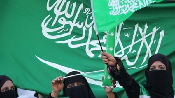 نساء سعوديات يحملن علم المملكة العربية السعودية