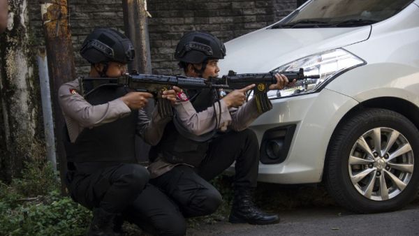 Mobile brigade police take position as they patrol outside the Surabaya police headquarters following a suicide attack in Surabaya on May 14, 2018. (JUNI KRISWANTO / AFP)