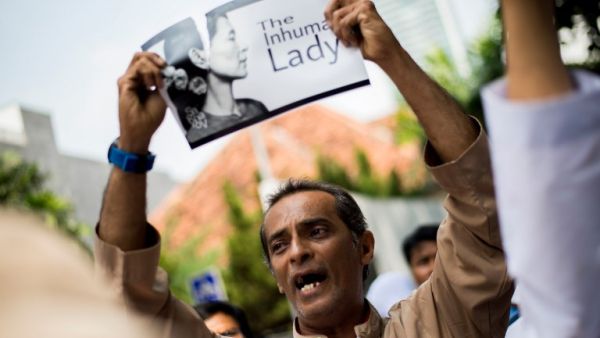 An Indonesian protester tears a picture of Aung San Suu Kyi during a rally in front of Myanmar embassy in Jakarta on September 2, 2017 (AFP)