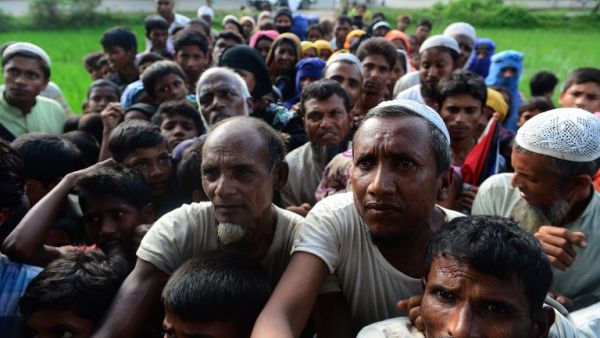 Rohingya people wait for relief supplies near a refugee camp in Kutupalong in the Bangladeshi district of Ukhia on September 8, 2017 (Munir Uz Zaman/AFP)