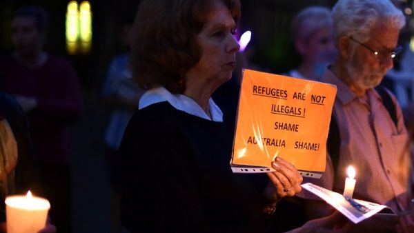 This picture taken on April 30, 2016 shows participants holding placard and candles during a vigil in Sydney for an Iranian refugee who died after setting himself on fire on the Pacific island of Nauru. (AFP/Saeed Khan)