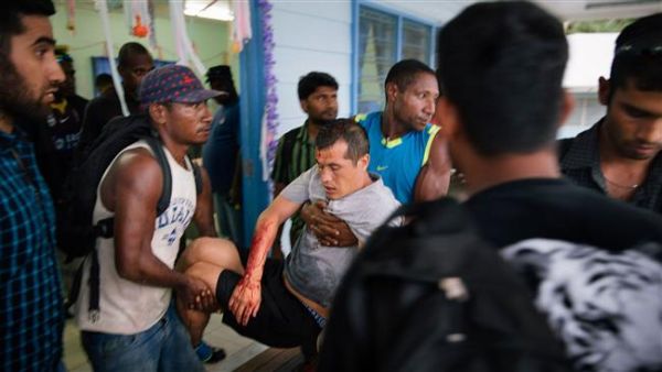 File photo of an injured Afghan refugee (C) from an Australian detention facility in Manus Island being carried by two men after he was allegedly attacked by a group of Papua New Guinean men while out on a day release. (AFP/File) 