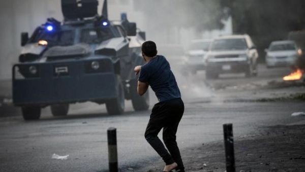 A Bahraini demonstrator hurls a rock towards riot police during clashes following the funeral of Hussein Abdullah, in the village of Saar, west of Manama, on June 26 (AFP)