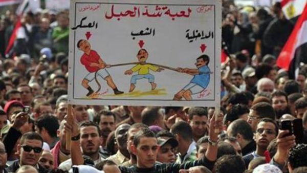 رجل يرفع لافتة خلال الاحتجاج ضد المجلس العسكري بميدان التحرير بالقاهرة يوم الجمعة