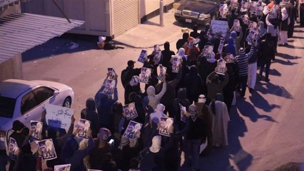 Bahrainis protest death sentences issued against three of their compatriots, while holding up protest placards and pictures of jailed cleric Sheikh Issa Qassim, in the northwestern village of Diraz, January 15, 2014. (File photo)