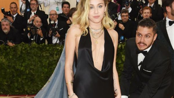 Miley Cyrus opted to go sans bra in a very plunging black gown by Stella McCartney that exposed not only some of her tattoos but generous glimpses of flesh. (Source: NEILSON BARNARD / GETTY IMAGES NORTH AMERICA / AFP)
