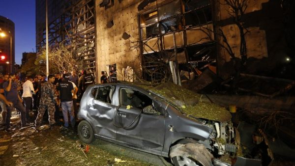 Security officials and civilians survey the aftermath of an explosion outside of Blom Bank in Beirut on the night of June 12, 2016. (AFP/Anwar Amro)