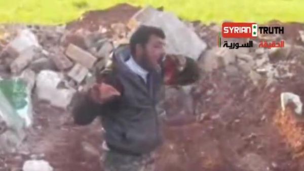 A Syrian rebel eats the heart of a dead Syrian solider.( YouTube screen-grab)