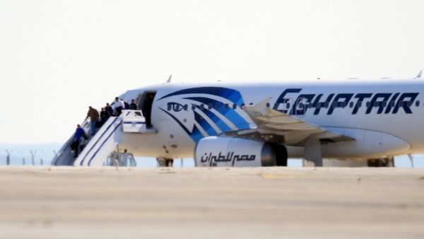 Passengers leave an EgyptAir Airbus A-320 after it was hijacked after leaving Alexandria for Cairo and diverted to Cyprus on March 29, 2016. (AFP/George Michael)