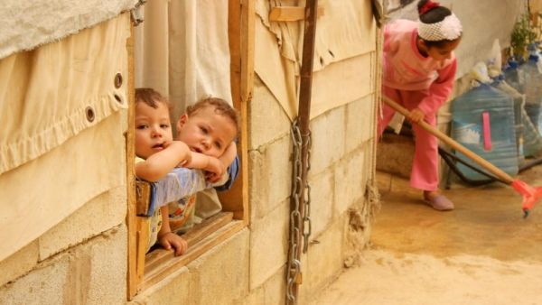 Syrian refugee children look on from a window during a sandstorm at a refugee camp on September 8, 2015 near the Bekaa Valley village of Taalabaya Lebanon. (AFP/File)