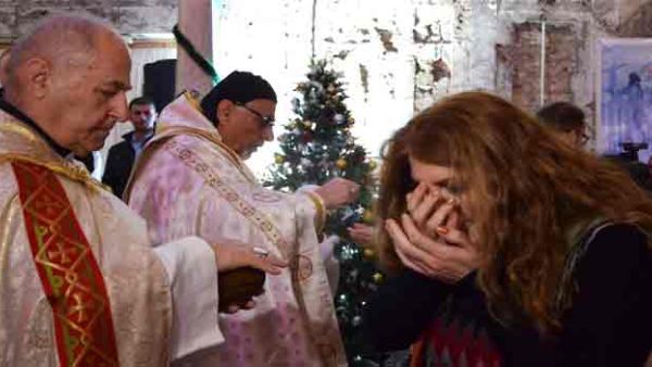 An Iraqi receives the Eucharist during a Christmas mass at the Saint Paul’s church on December 24, 2017 in the country’s second city Mosul. (Ahmad MUWAFAQ / AFP)