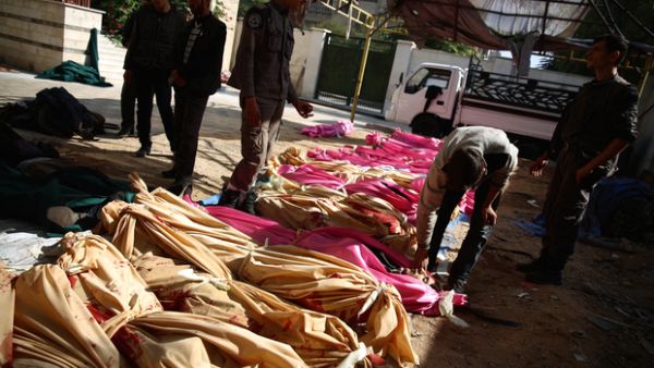 People identify the bodies of loved ones following a reported airstrike by Syrian government forces on the rebel-held town of Douma (AFP/File Photo)	