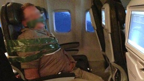 A passenger bound with tape allegedly aboard an Iceland Air flight from Reykjavik to New York. (Twitter)