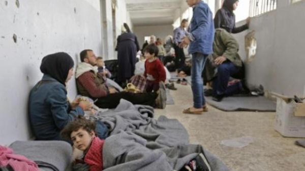 مدنيون سوريون فروا من الغوطة الشرقية داخل مركز استقبال للحكومة السورية في عدرا

