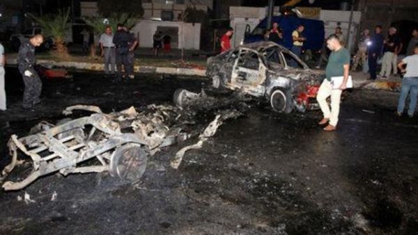 قوة أمن عراقية تعاين موقع تفجير سيارة ملغومة في مدينة كركوك في شمال العراق
