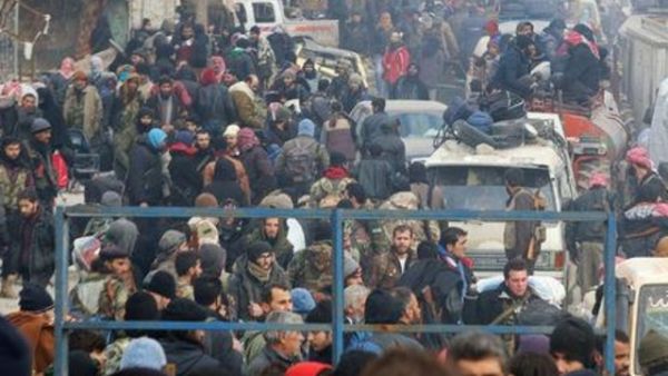 مقاتلو معارضة ومدنيون يتجمعون انتظارا لإجلائهم من منطقة تسيطر عليها المعارضة في شرق حلب يوم الجمعة

