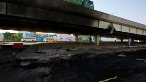 أناس يسيرون في الموقع الذي شهد تفجيرا انتحاريا عند مجمع النخيل التجاري قرب وزارة النفط العراقية في العاصمة بغداد يوم السبت
