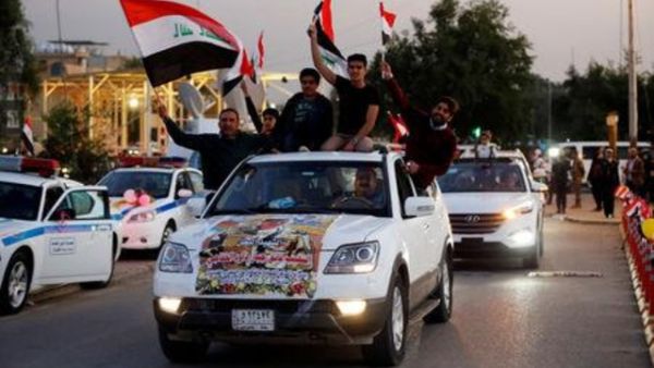 عراقيون يرفعون علم بلادهم احتفالا بالذكرى الاولى للانتصار على تنظيم الدولة الاسلامية في بغداد
