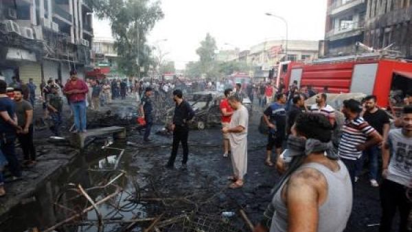 أشخاص في موقع تفجير انتحاري في حي الكرادة ببغداد
