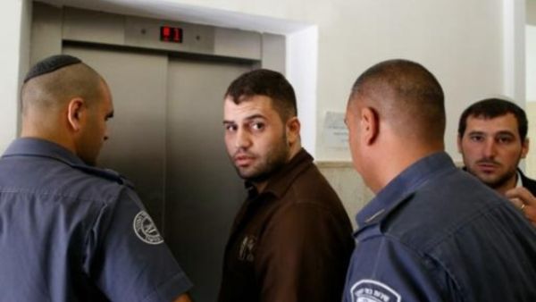 الفلسطيني بلال ابو غانم لدى مغادرة المحكمة بين جنود اسرائيليين في القدس
