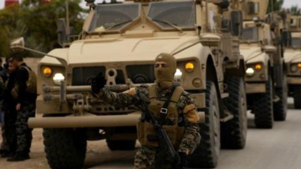 عناصر من قوات سوريا الديموقراطية وجنود اميركيون يقومون بدورية في بلدة الدرباسية في شمال شرق سوريا قرب الحدود التركية

