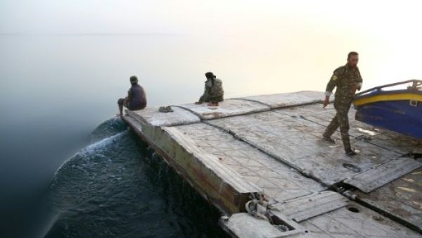 عناصر من قوات سوريا الديموقراطية عند بحيرة الاسد التي تشكلت مياهها من سد الطبقة
