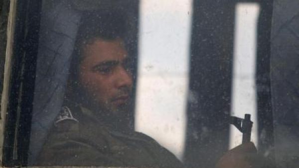 مقاتل في المعارضة السورية يمسك سلاحه على متن حافلة تستعد لمغادرة حي الوعر في حمص
