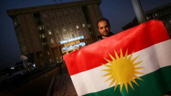 يحمل العلم الكردي امام مقر برلمان كردستان العراق في اربيل

