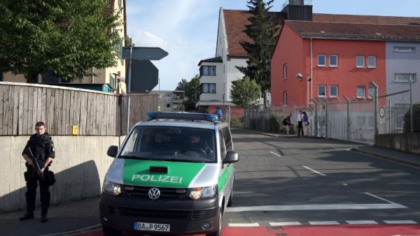 A pliceman stands near a migrant reception center on July 27, 2016 in Zirndorf, southern Germany, following an explosion of a suitcase. (AFP/Daniel Karmann) A pliceman stands near a migrant reception center on July 27, 2016 in Zirndorf, southern Germany, following an explosion of a suitcase. (AFP/Daniel Karmann)