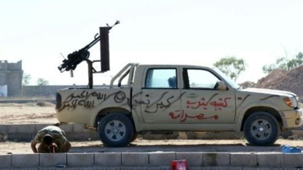 مقاتل ليبي تابع لحكومة الوحدة الوطنية يصلي قرب سيارة عسكرية في سرت
